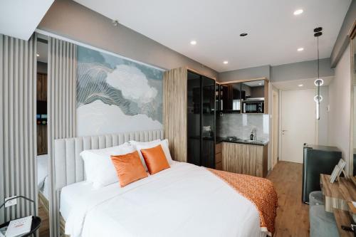 a bedroom with a white bed with orange pillows at Lavy at Anderson Pakuwon Mall in Surabaya