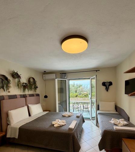 a bedroom with a bed and a table and a balcony at Aliki Studios in Parga