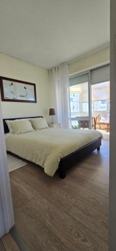 a bedroom with a large bed and a large window at Casa Mar in Costa da Caparica