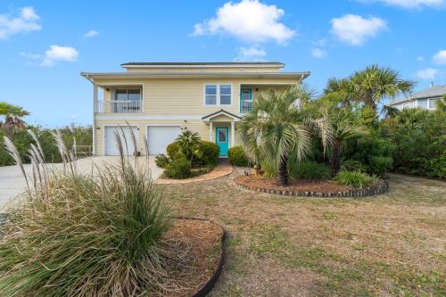 a house with palm trees in front of it at Flip Side Oasis Beach House in Pensacola Beach