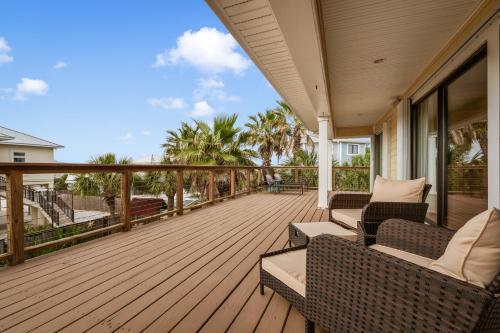a wooden deck with chairs and tables on a house at Flip Side Oasis Beach House in Pensacola Beach