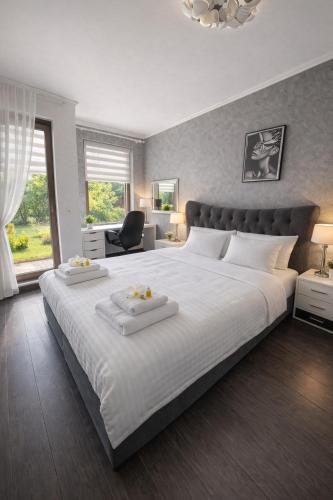 a large white bed with two white towels on it at Marica Apartment in Plovdiv