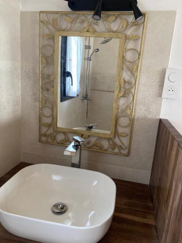 a bathroom with a white sink and a mirror at Chambre Lucioles in Orniac
