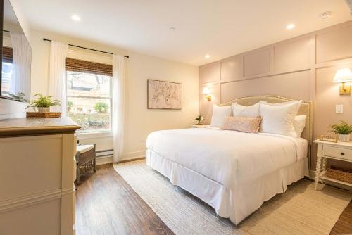a bedroom with a large white bed and a window at Kildahl House - Boutique Farmhouse Suite #1 in West Dundee
