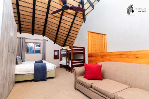 a living room with a couch and a bed at INYAMATANE LUXURY LODGES at Kruger Park Lodge in Hazyview