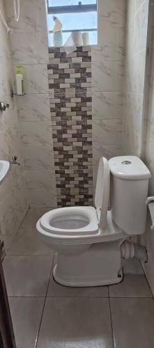 a bathroom with a white toilet and a sink at Soney Homes in Nairobi