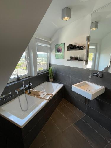 a large bathroom with a tub and a sink at Modernes Apartment in Haiger Allendorf in Haiger