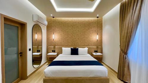 a hotel room with a large bed and a mirror at Aurhom By Royal Inn in Karachi
