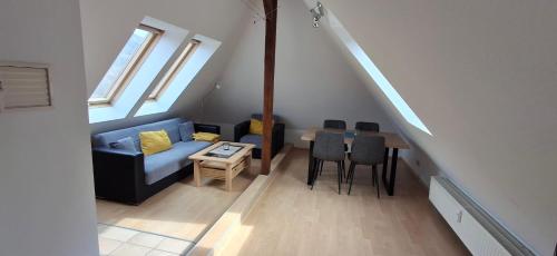 a living room with a couch and a table with chairs at Ferienwohnung Menz Liliensteinblick in Pfaffendorf