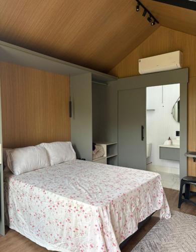 a bedroom with a large bed with a pink blanket at Chalé Loft in Lavrinhas