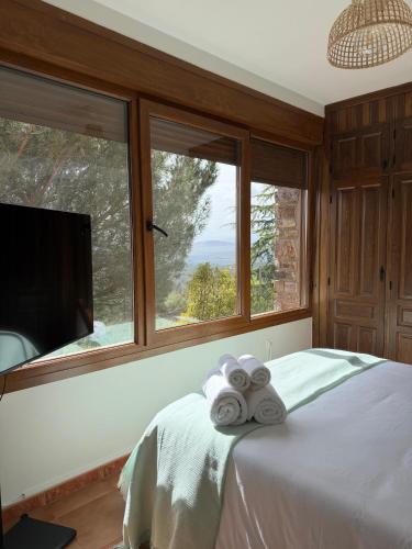 a bedroom with a bed with two rolled towels at Atempo Berzosa Arce in Berzosa del Lozoya