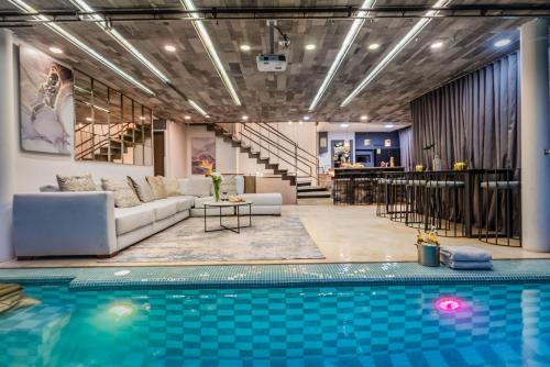 a living room with a pool and a couch and a bar at Ultimate 9BR Lleras Villa W Heated Pool in Medellín