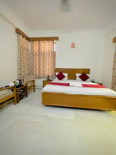 a bedroom with a large bed with red pillows at Hotel Har Ki Pauri with terrace Ganga view in Haridwār