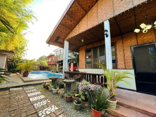 a building with a bunch of potted plants in front of it at Soulelle Villa in Silang