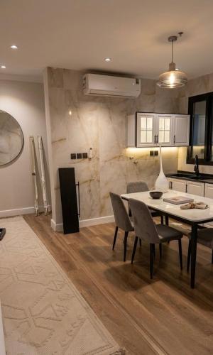 a kitchen and dining room with a table and chairs at نسمة الخبر كورنيش اقامة رائعة وهادئة in Dammam