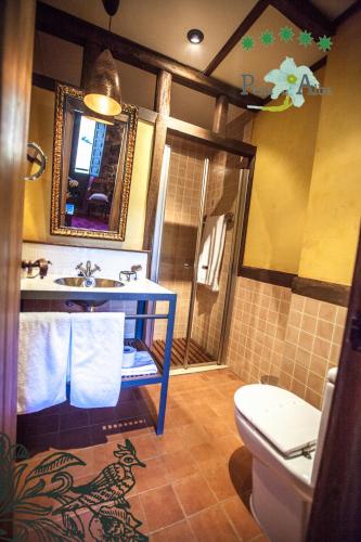 a bathroom with a sink and a toilet at Hotel Ruralis Peña Del Alba in Arroyomolinos de la Vera