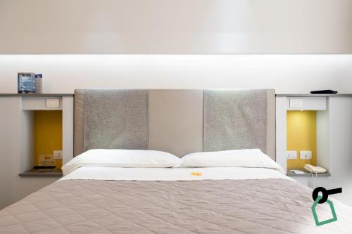 a bedroom with a large bed with white sheets at Hotiday Brindisi Vittoria in Brindisi