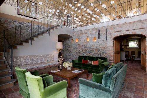 a living room with green furniture and a staircase at Relais dei Poderi Einaudi in Dogliani