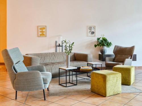 a living room with a couch and chairs at Flemings Hotel Bremen-Hauptbahnhof in Bremen