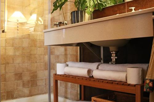 a bathroom with a sink and a bench with towels at Studio City Center - Aloha Sevilla in Seville