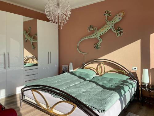 a bedroom with a bed with lizard decals on the wall at Appartamento Ato La Gerbia in Cannobio