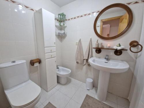 a bathroom with a toilet and a sink and a mirror at Sea View Apartman Daimus in Daimuz
