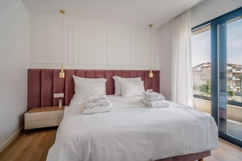 a bedroom with a large white bed with towels on it at Adria Concept Suites in Zadar