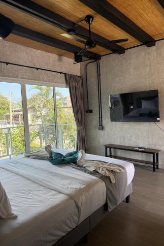 a bedroom with a large bed with a tv on the wall at Surf & Sand Resort in Hua Hin