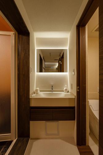 a bathroom with a sink and a mirror at oyasumi hotel 道頓堀 Zero-pressure mattress in Osaka