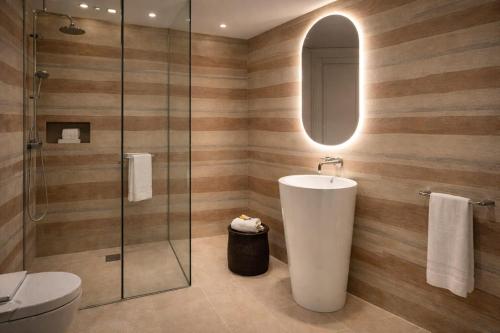 a bathroom with a sink and a glass shower at Hotel Sayonara in Milano Marittima