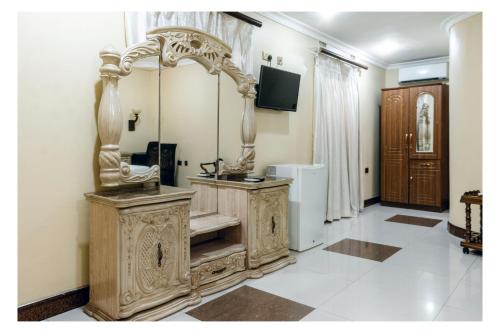 a bathroom with a wooden vanity with a mirror at Leon's Hotel in Choma