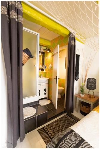 a room with a bathroom with a sink and a mirror at La Joliette in Junas