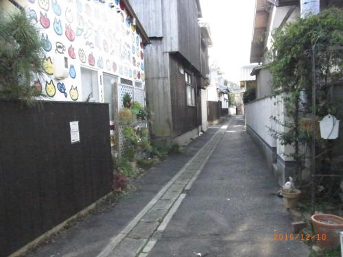 un callejón con una pared con placas. en Oyajino Umi en Naoshima