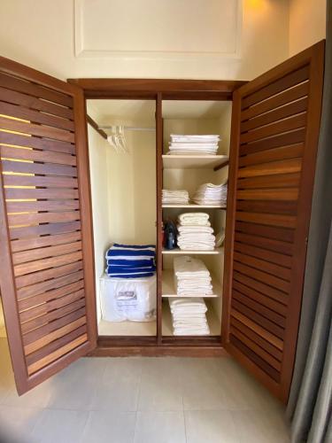 a walk in closet with wooden doors and towels at Mandharini UNIT 35 in Kilifi