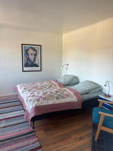 a bedroom with a bed and a rug at Fjærestua in Hitra