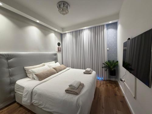 a bedroom with a large white bed with towels on it at Golf Residence Suite & pool in Eilat