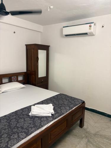 a bedroom with a bed with a white towel on it at Rainbow721 Earth in Pondicherry