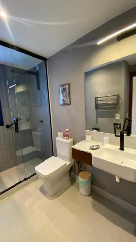 a bathroom with a toilet and a shower and a sink at Pousada Casa Zoe Búzios in Búzios