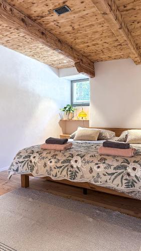 a large bed in a room with a wooden ceiling at Cavigliano Rustico - free parking in Cavigliano