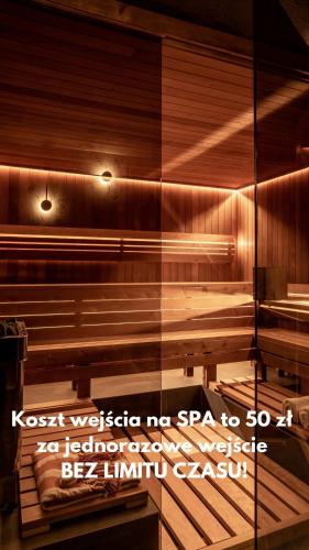 a reflection of a sauna with a sign in a window at OBERŻA POD RÓŻĄ restauracja, sauny, jacuzzi in Nowy Targ