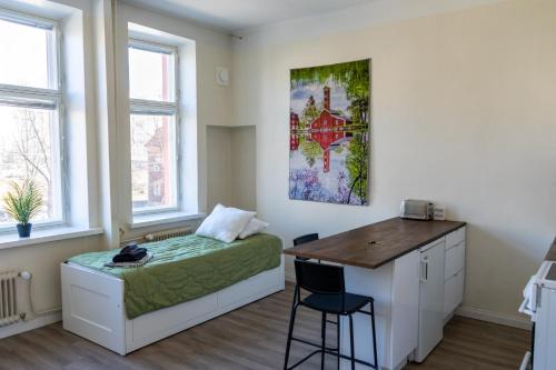 a bedroom with a bed and a desk and a table at Grand Jugend Studio in Kallio in Helsinki
