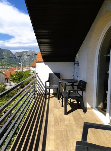 a balcony of a house with a table and chairs at Pure Sky Apartments - with pool in Mostar