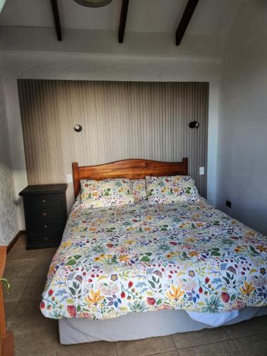 a bed with a floral comforter in a bedroom at Ilocavistamar in Iloca