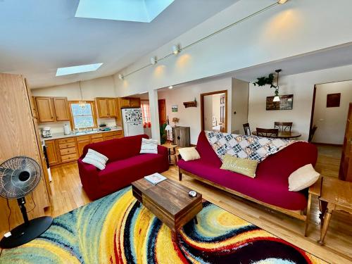 a living room with two red couches and a kitchen at The Suite at Liberty Woods in Belchertown