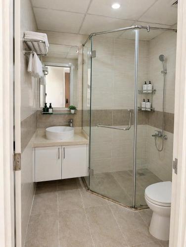 a bathroom with a shower and a sink and a toilet at Monarchy Luxury Serviced Apartments - By Charm Homestay Vietnam in Danang