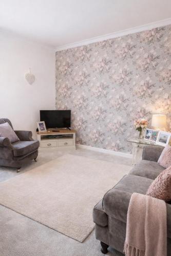 a living room with a couch and a tv at Cosy Alnwick Apartment in Alnwick