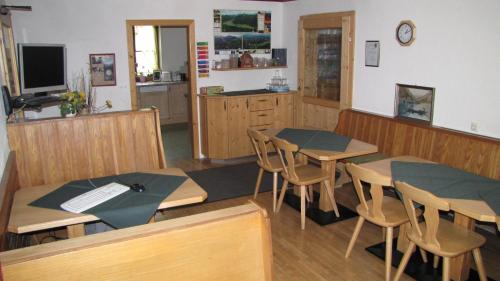 a classroom with tables and chairs and a kitchen at Pension Sydler in Bad Goisern