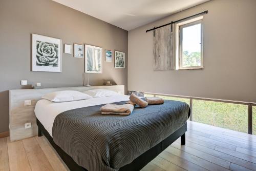 a bedroom with a bed with two towels on it at La Pause Camarguaise in Saint-Laurent-dʼAigouze