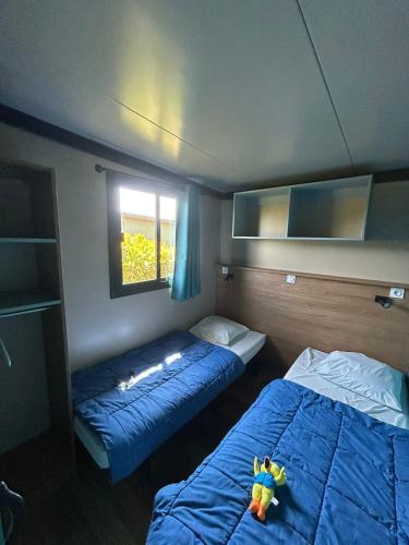 a room with two beds and a window at Camping Paradis l'Arada Parc in Sonzay