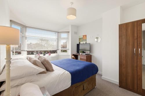 a bedroom with a large bed and a window at 4BR with Private Parking in Wyken